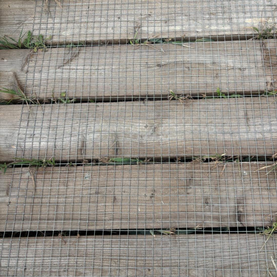 Square welded wire mesh covering timber decking, with wires running at right angles