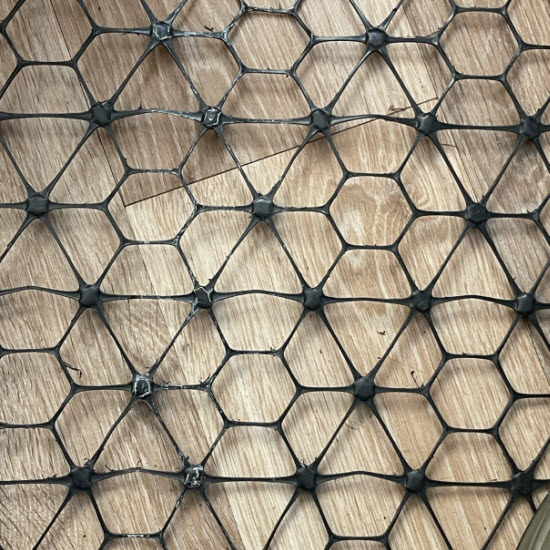 Black Tensar decking mesh on timber, showing ribs in three directions and raised junctions