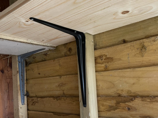 Wooden garden shed shelf with metal bracket