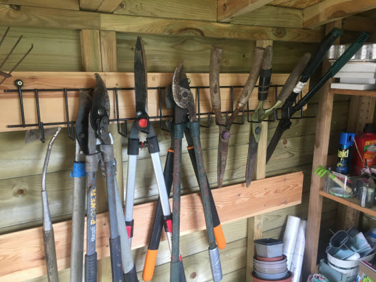 Planks fixed to shed wall for hanging tools
